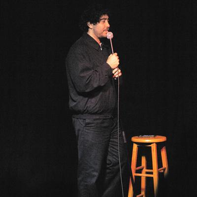 A comedian performing on the Club Voltaire stage