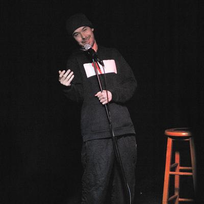 A comedian performing on the Club Voltaire stage