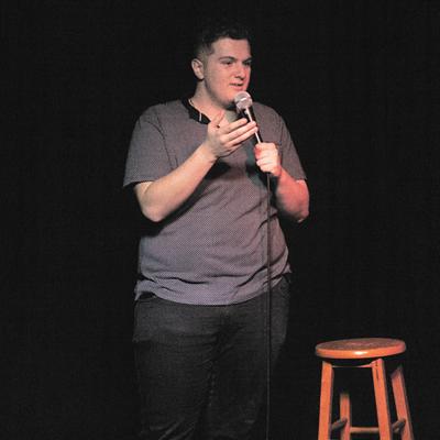 A comedian performing on the Club Voltaire stage