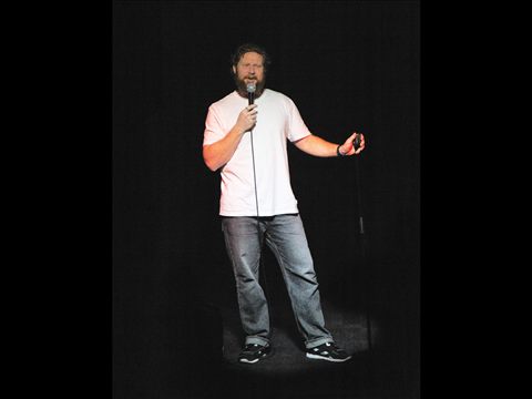 A comedian performing on the Club Voltaire stage