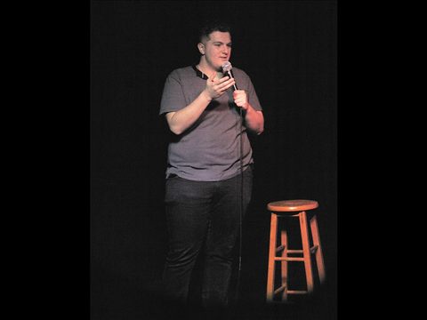 A comedian performing on the Club Voltaire stage
